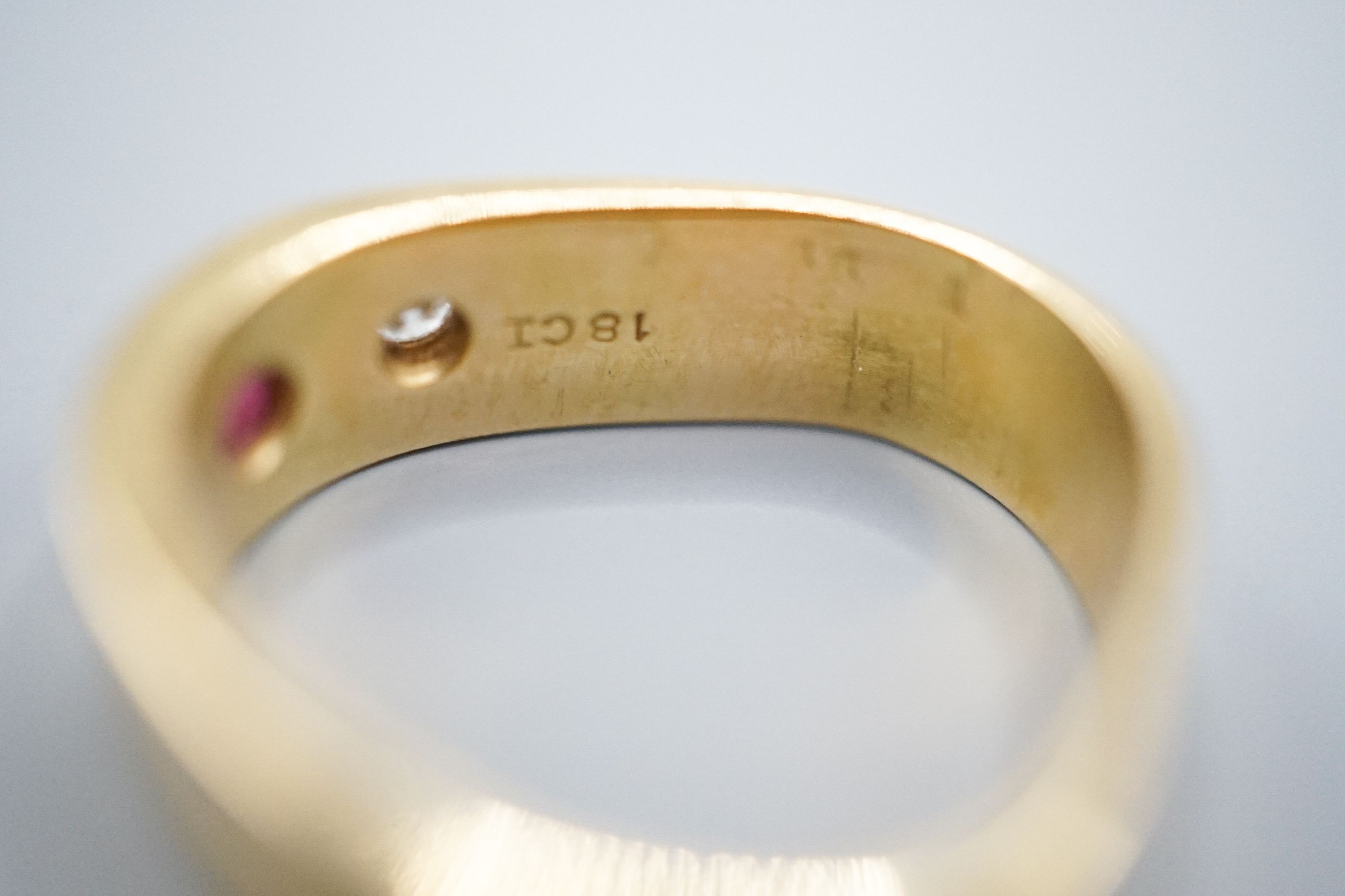 An 18ct and gypsy set three stone ruby and diamond ring, of triangular form, size O/P